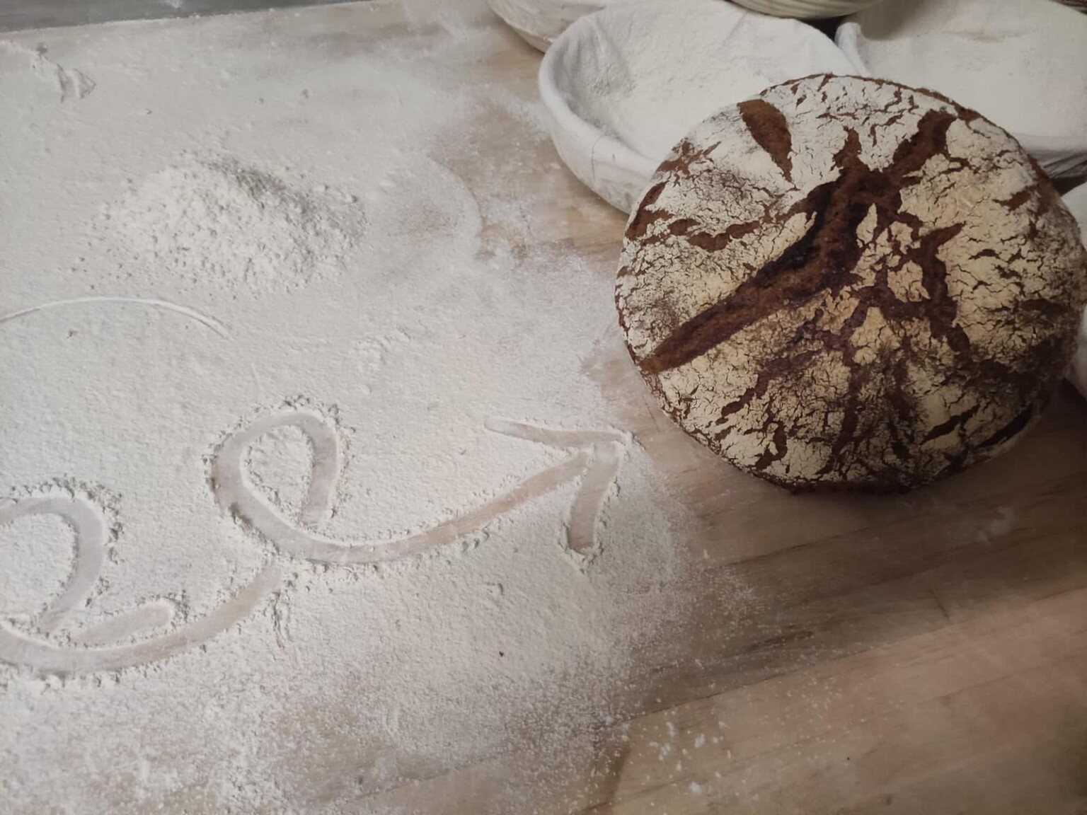 Rustikales Bio-Sauerteigbrot auf der bemehlten Arbeitsfläche in unserer Backstube